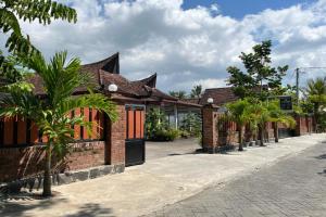 uma fila de casas de tijolos numa rua em Capital O 92615 Villa Utama D'alas Purwo em Ringinpintu