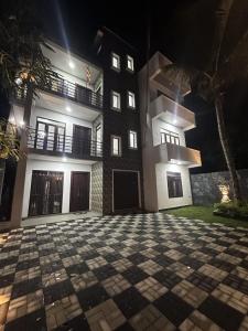 an empty courtyard in front of a building at night at DreamScape Holiday Apartment in Kalutara