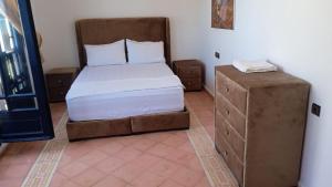 a small bedroom with a bed and a dresser at Soultana 4 pour les familles in Oualidia