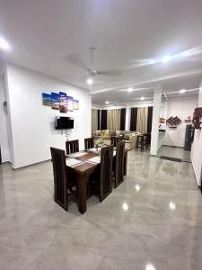 a dining table and chairs in a living room at DreamScape Holiday Apartment in Kalutara