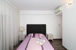a bedroom with a bed with two towels on it at Gulf Palace Apartments in Limassol