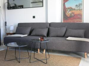 a living room with a gray couch and two tables at Sotogrande Duplex near Polo, 2 terraces, 2 pools, full south, 7' drive to beaches and Port, 4 people in Sotogrande