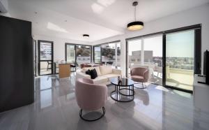 a living room with a couch and chairs and windows at Premier 403 3 bedroom penthouse in Paphos