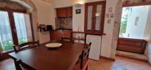 a kitchen with a wooden table and a refrigerator at Sotto l'arco in Sammichele di Bari +9 photos