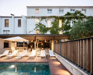a balcony with chairs and a swimming pool at Les Elmes - H&ocirc;tel, Spa & Plage Priv&eacute;e in Banyuls-sur-Mer