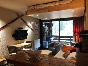 een woonkamer met een bank en een tafel bij Studio Pra-Loup, 1 pièce, 4 personnes - FR-1-165A-14 in Uvernet