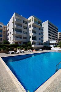 a large swimming pool in front of two buildings at Gulf Palace Apartments in Limassol