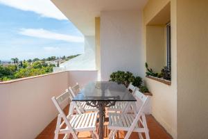 a glass table and chairs on a balcony at Hauzify I Villa del Castell in Altafulla