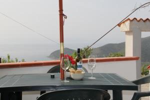 una mesa con dos copas y una botella de vino en Casa Vacanze vista mare a Castellabate en Castellabate