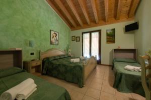 a bedroom with two beds in a room with green walls at Agriturismo Ca' Del Gal in Valeggio sul Mincio