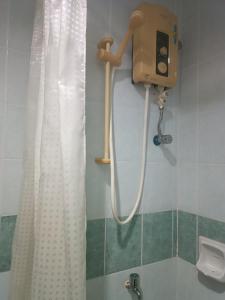 eine Dusche im Bad mit einem weißen Duschvorhang in der Unterkunft Sofea Inn Bukit Merah - Laketown A6153 in Kampong Selemat