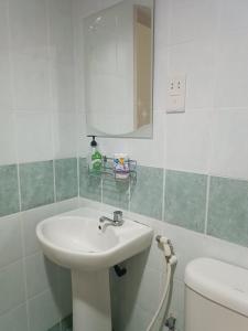 ein Badezimmer mit einem Waschbecken, einem WC und einem Spiegel in der Unterkunft Sofea Inn Bukit Merah - Laketown A6153 in Kampong Selemat