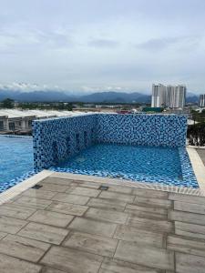 a swimming pool with blue tiles on the side of a building at idaman hill homestay in Ipoh