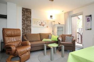 ein Wohnzimmer mit einer Couch und einem Sessel in der Unterkunft Urlauberdorf Haus 31d in Boltenhagen