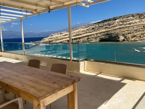 Bella Vista Luxury Apartment في ماتالا: طاولة مع كراسي وإطلالة على الماء