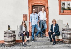 a group of people standing in front of a building with wine barrels at Hotel Zeltinger-Hof - Gasthaus des Rieslings in Zeltingen-Rachtig