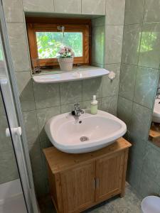 a bathroom with a sink and a window at Búzavirág Apartman in Szentbékkálla