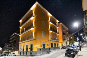 um edifício amarelo numa rua da cidade à noite em Acate81 Lifestyle Apartment em Nápoles