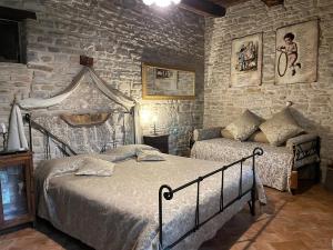 a bedroom with two beds and a stone wall at Agriturismo Biologico Castello Della Pieve in Mercatello sul Metauro