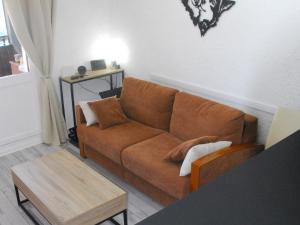 a living room with a brown couch and a table at Studio Pra-Loup, 1 pièce, 4 personnes - FR-1-165A-98 in Uvernet-Fours