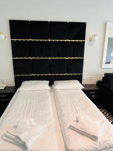 Dos camas en una habitación con toallas blancas. en Apartament Solny Resort A032 z klimatyzacją, en Kołobrzeg