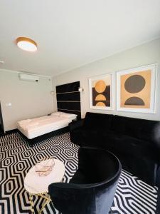 a living room with a black couch and chairs at Apartament Solny Resort A032 z klimatyzacją i ogrodem in Kołobrzeg
