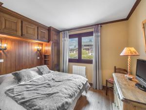 Schlafzimmer mit einem Bett und einem Schreibtisch mit einem TV in der Unterkunft Appartement Megève, 3 pièces, 4 personnes - FR-1-453-271 in Megève