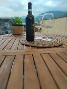 a bottle of wine and two glasses on a wooden table at La casa di Ottavio in Giaveno