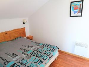 sypialnia z łóżkiem i narzutą, na której nie ma napisu „nic” to wszystko, co jest w obiekcie Charmant Chalet Duplex 6 Pers, Résidence 3* avec Piscine, Superdevoluy, à 300m des Pistes - FR-1-504-634 w mieście Superdevoluy