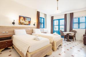 a hotel room with two beds and a table at Livadia Beach Tilos Apartment in Livadia