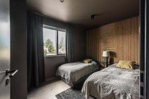 1 dormitorio con 2 camas y ventana en Thingvallastræti, en Akureyri