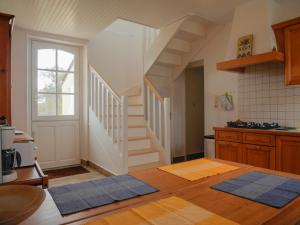 une cuisine avec un escalier et des tapis bleus au sol dans l'établissement Maison Locmaria, 6 pièces, 9 personnes - FR-1-418-199, à Locmaria