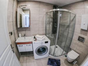a bathroom with a shower and a washing machine at Evalacati - Stylish Flat Blue in Cesme +23 photos