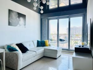 a living room with a white couch and a large window at Promenada Gwiazd by Baltic Home in Międzyzdroje +54 photos