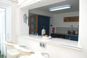 a kitchen with two white chairs and a counter at Spacious 4 Bed Victorian House with Sea Views in Ilfracombe
