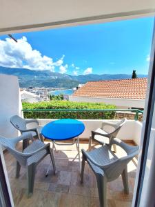 d'un balcon avec des chaises, une table bleue et des chaises. dans l'établissement Apartmani Cupic, à Budva