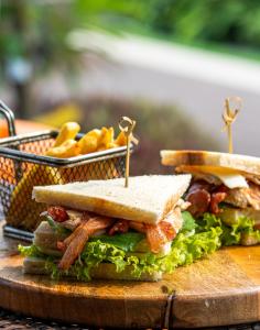 a sandwich on a cutting board with a basket of food at Fairfield by Marriott Goa Benaulim in Benaulim