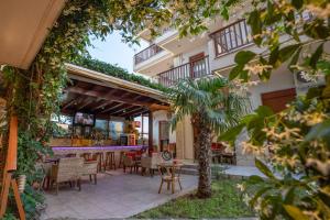 a patio with tables and chairs and a building at Erifili Kallithea in Kallithea Halkidikis