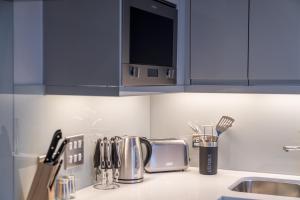 a kitchen counter with utensils on a counter top at ALTIDO Tasteful flat with balcony in London