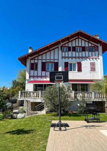ein großes Haus mit einem Basketballkorb davor in der Unterkunft Belle maison familiale Basque in Bayonne