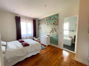a bedroom with a bed and a dresser and a mirror at Belle maison familiale Basque in Bayonne