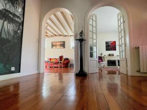 a living room with a wooden floor and two arches at Belle maison familiale Basque in Bayonne