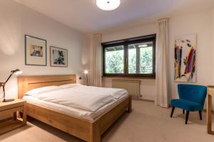 ein Schlafzimmer mit einem Bett und einem blauen Stuhl in der Unterkunft Chalet Luis in Pfalzen
