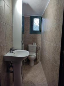 baño con lavabo y aseo y ventana en KATKA Karavas, en Citera