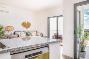 eine Küche mit einer Arbeitsplatte und ein Wohnzimmer in der Unterkunft Sun Sand Surf Apartment - Brand New & Cozy Apt in Aljezur in Aljezur + 20 Fotos