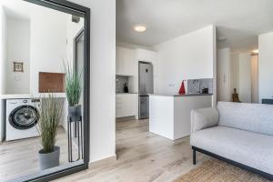 ein Wohnzimmer mit einem Stuhl und eine Küche in der Unterkunft Sun Sand Surf Apartment - Brand New & Cozy Apt in Aljezur in Aljezur
