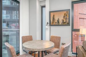 a table and chairs in a room with a window at JOIVY Tasteful flat with balcony in London