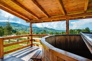 a wooden deck with a view of the mountains at Casa din Munți Vlădeasa in Rogojel