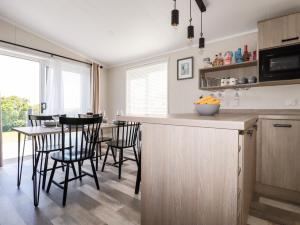 een keuken met een aanrecht en een tafel met stoelen bij 63 The Maples in St Austell