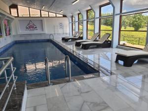 a swimming pool in a building with chairs at La Vie En Rose Hotel by Sogutdagi Isparta in Keçiborlu